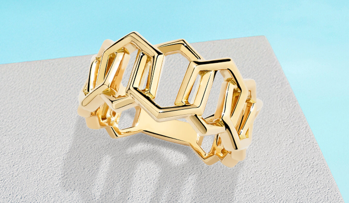 Birks Bee Chic yellow gold ring on a blue background.